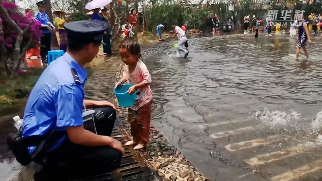 太暖心了！警察叔叔蹲下接受小朋友的泼水祝福