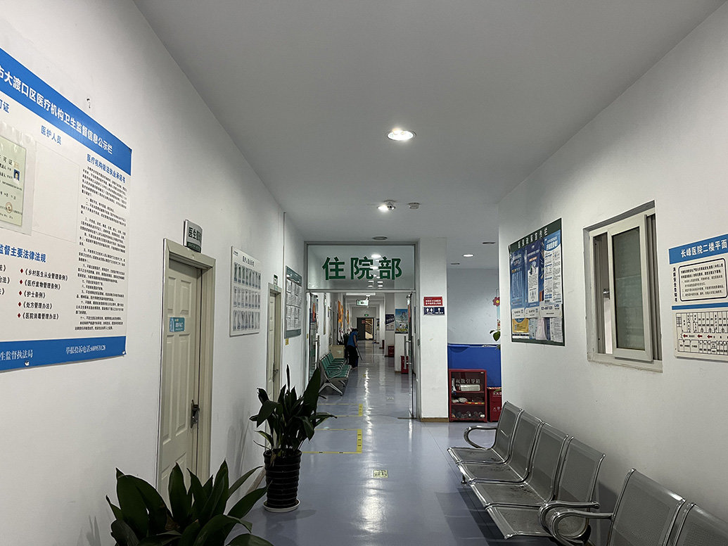 重庆长峰医院二楼一景，住院部入口旁放有疏散引导箱和灭火器等消防设施。