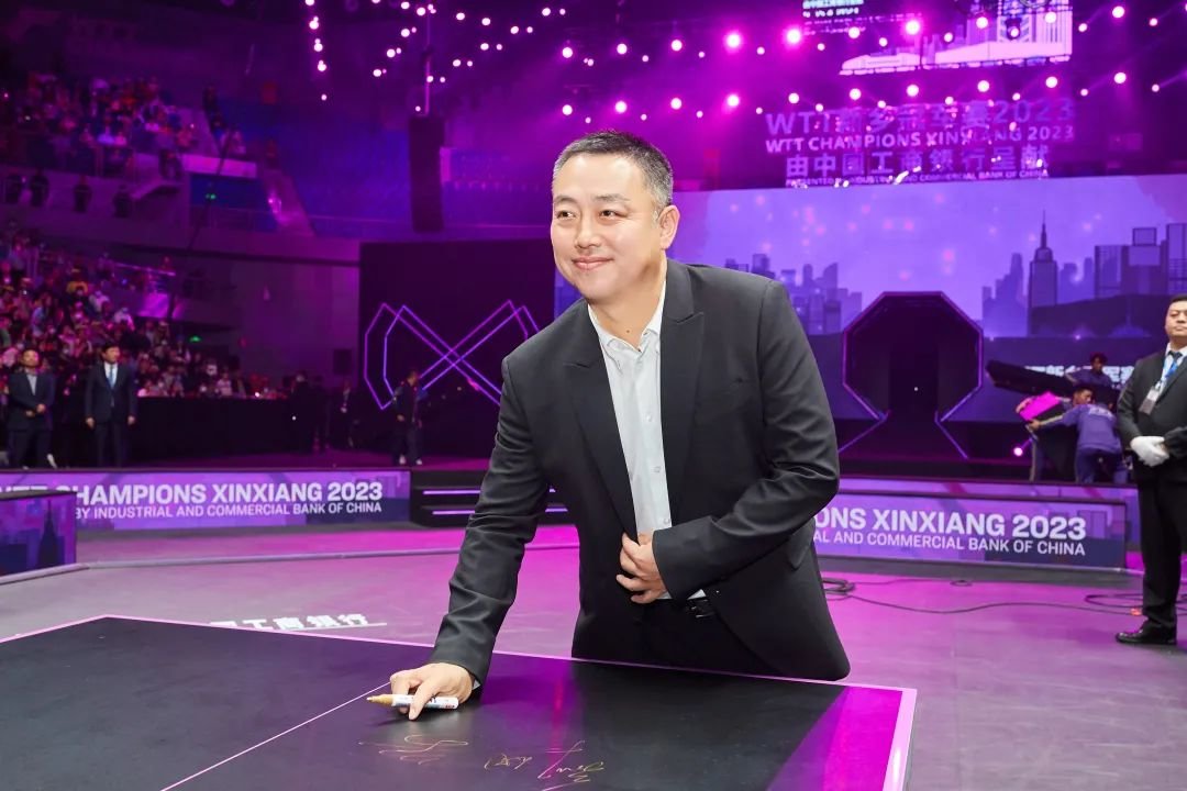 ▲刘国梁在冠军球台上签名