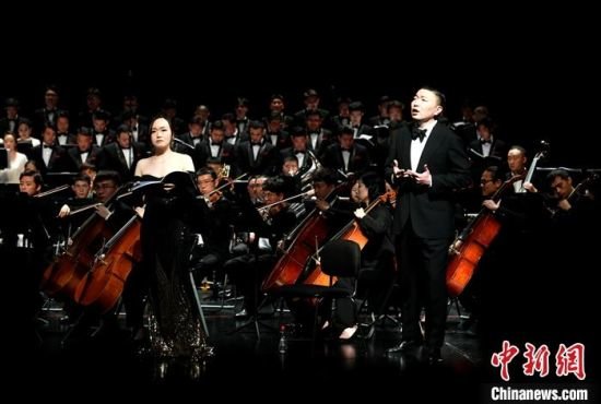 4月14日,著名作曲家谭盾作曲的交响乐作品《敦煌·慈悲颂》在位于福州的福建大剧院上演,海峡两岸暨香港音乐人一同参与演出。图为香港青年男高音陈晨与香港青年女高音邝励龄在台上演出。 中新社记者 吕明 摄