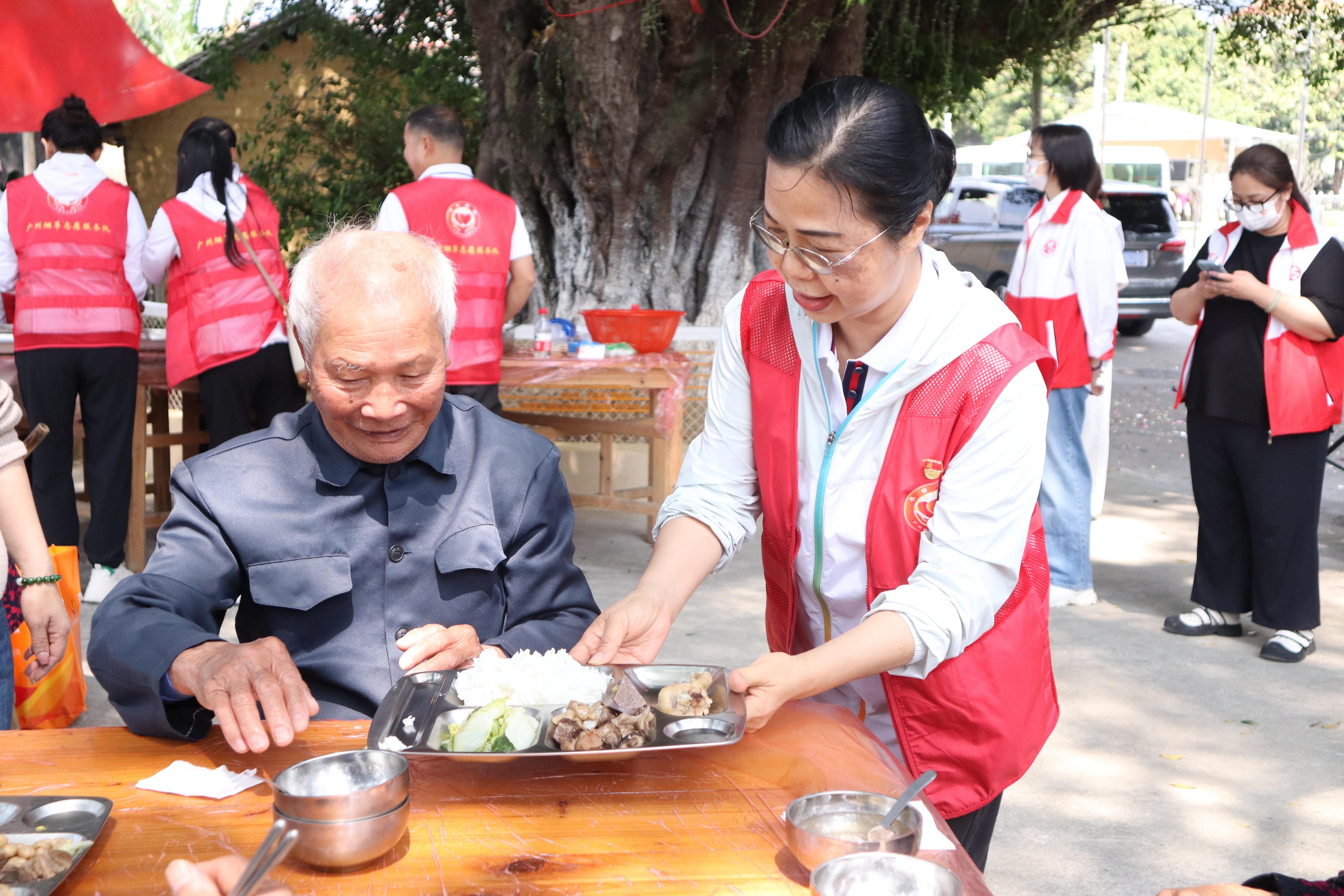 广州烟草冬日暖阳志愿服务队队员向长者送上暖心餐