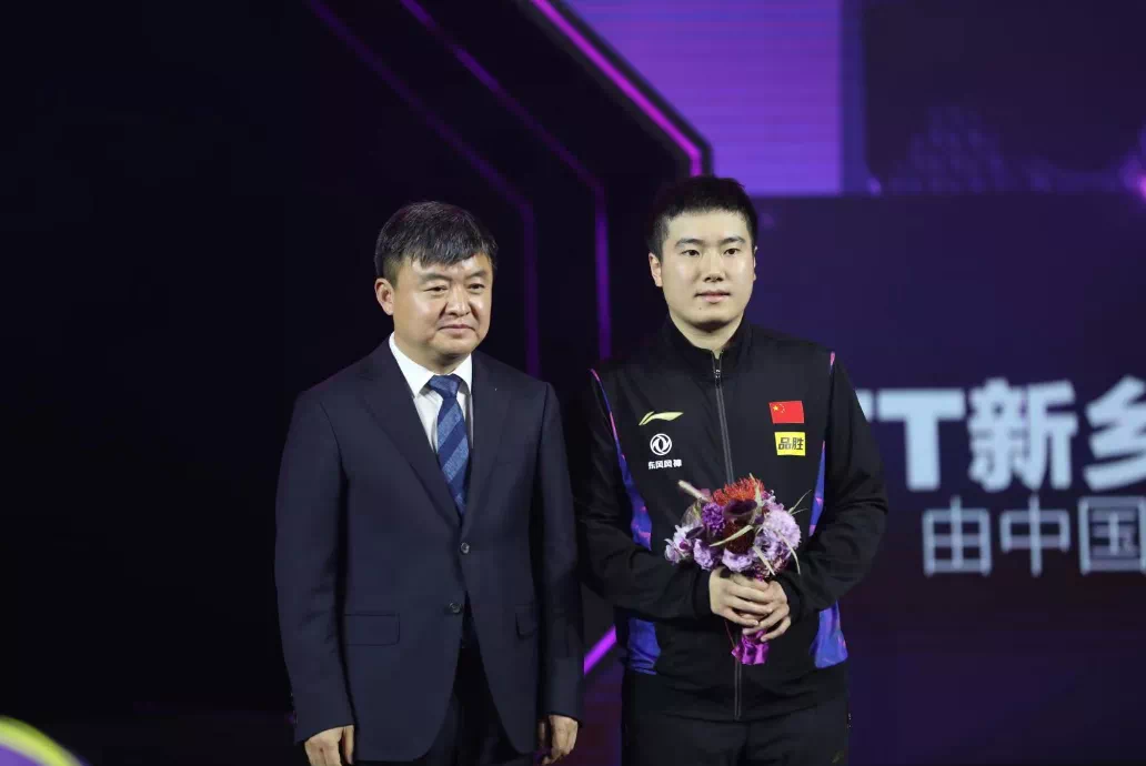 ▲孙栋为男单亚军梁靖崑颁发鲜花并合影