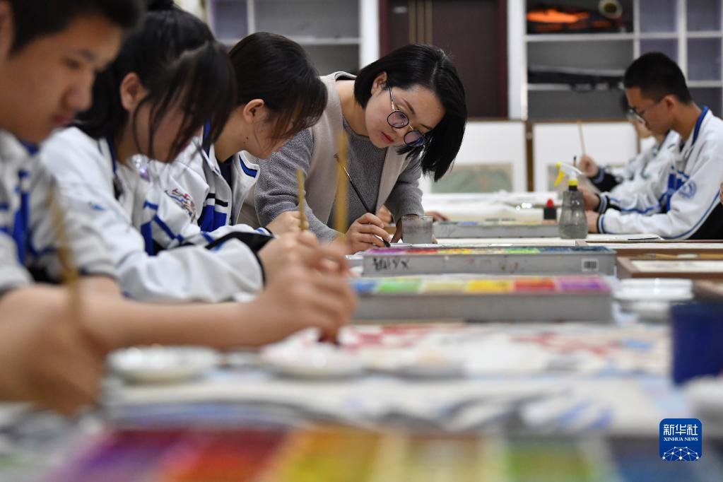4月26日，敦煌中学美术教师杨娜（左四）指导学生临摹敦煌壁画。