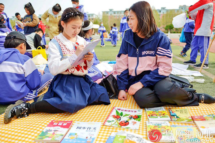 小记者与家长席地而坐，交流阅读感受。