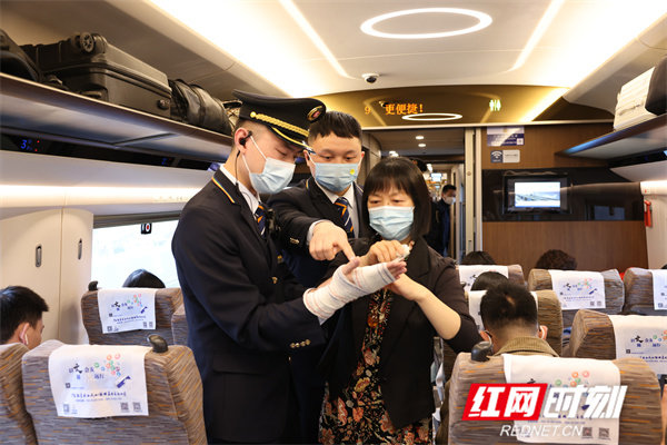 列车上的乘客积极参与安全演练,这位乘客在为列车长“包扎伤口”。
