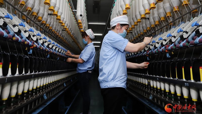 4月24日，工人在甘肃省平凉市泾川县天纤棉业有限责任公司纺织车间生产线上赶制订单。