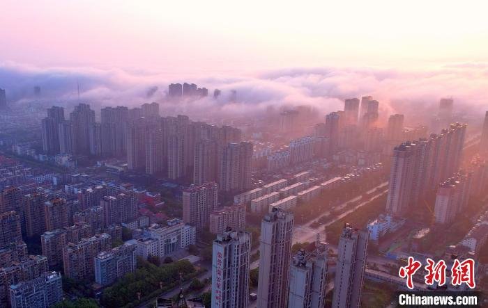 图为抚州主城区上空云雾缭绕,金色晨曦洒向大地,城市建筑若隐若现,壮美如画。 熊慧平 摄
