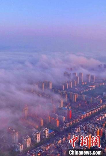 图为抚州主城区上空云雾缭绕,城市建筑若隐若现。 熊慧平 摄