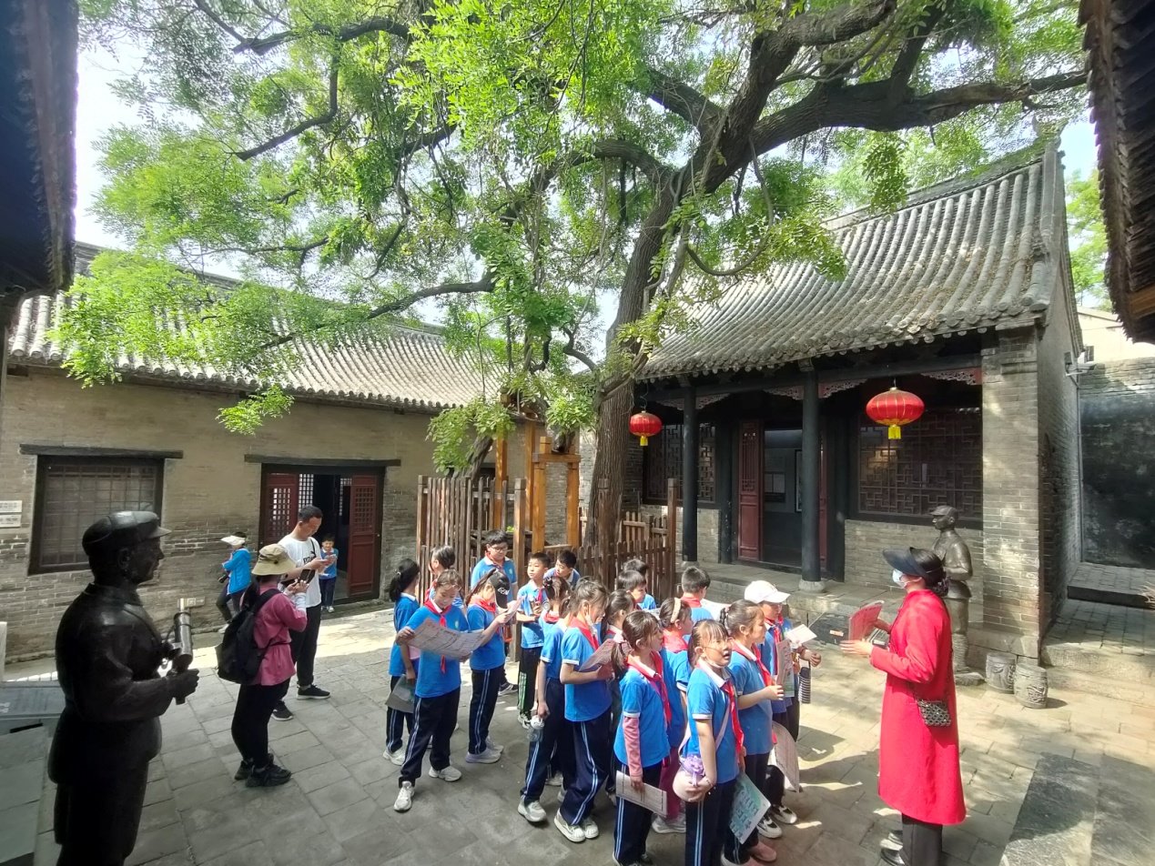 研学学生聆听导游讲解红色教育故事