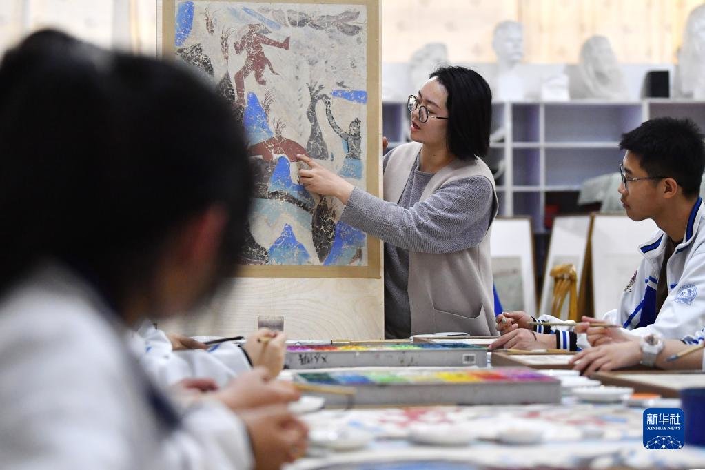 4月26日，敦煌中学美术教师杨娜为学生讲解敦煌壁画艺术。