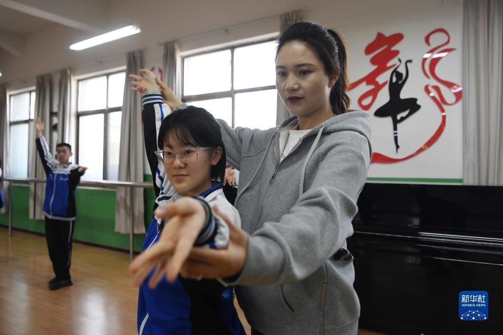 敦煌中学教师张梦婷(右)在舞蹈教室给学生纠正敦煌舞课间操的动作(4月26日摄) 新华社记者 陈斌 摄
