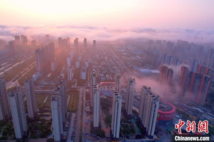 图为抚州主城区上空云雾缭绕,金色晨曦洒向大地,城市建筑若隐若现,壮美如画。 熊慧平 摄