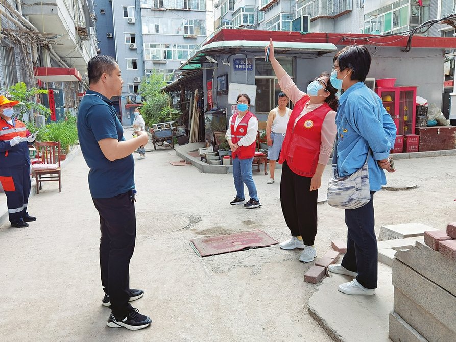校尉营连片小区网格员实地查看居民反映的问题。