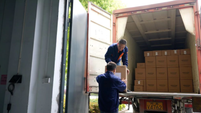 运输工人正在把打包好的镜片装车。