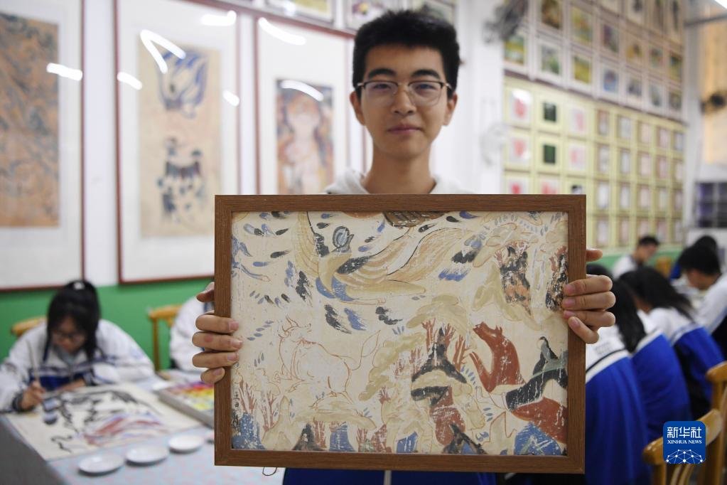 4月26日，敦煌中学学生陆适展示自己正在临摹的敦煌壁画作品。