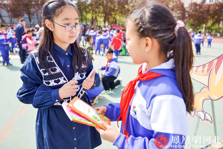 开发区第二小学的跳蚤书市上，小记者和同学展开阅读心得交流。