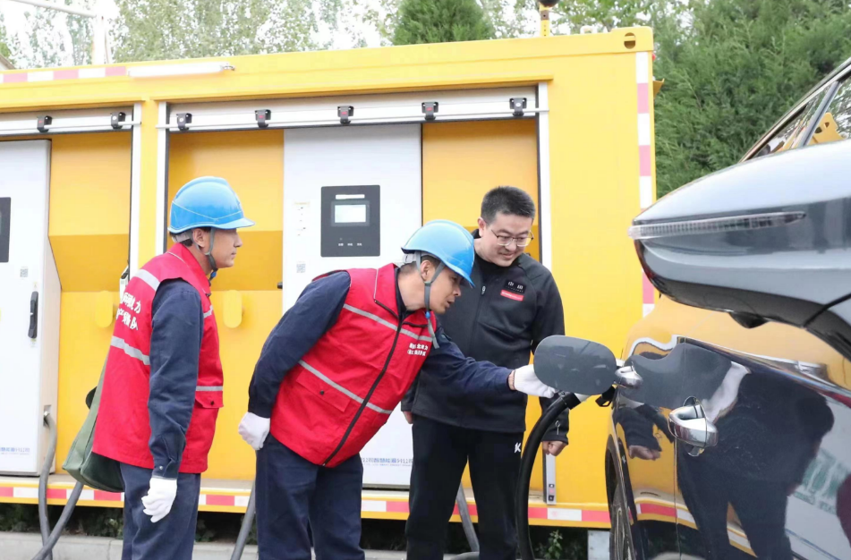 河北电力部门运维人员在大广高速西演服务区帮助电动汽车车主充电。(摄影:周靖仁)