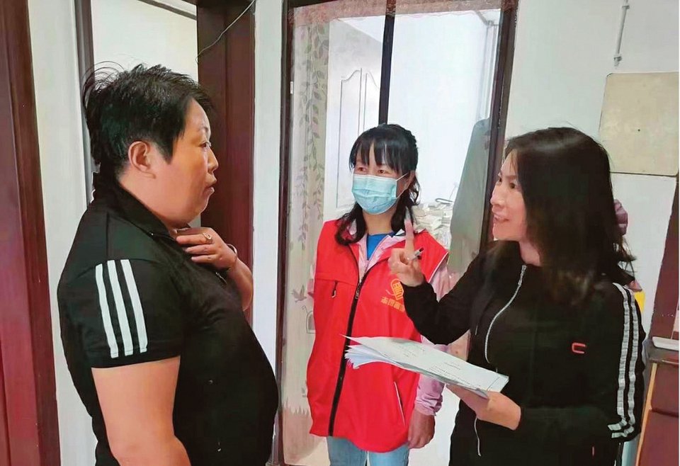 化肥小区党员志愿者上门帮助残疾居民办理补贴申请手续。
