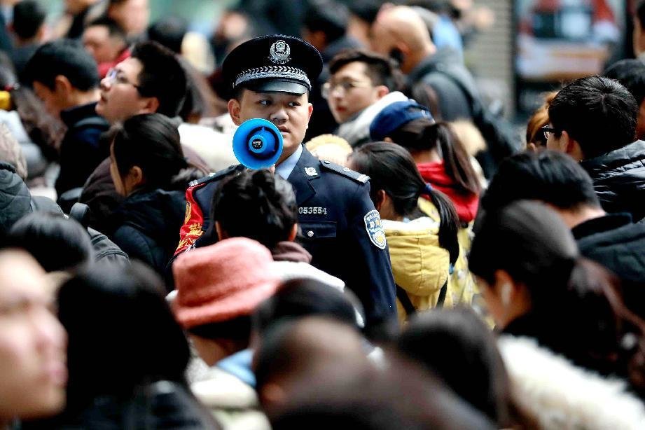 铁路民警正在维护进站乘车秩序，确保治安良好。周延民 摄