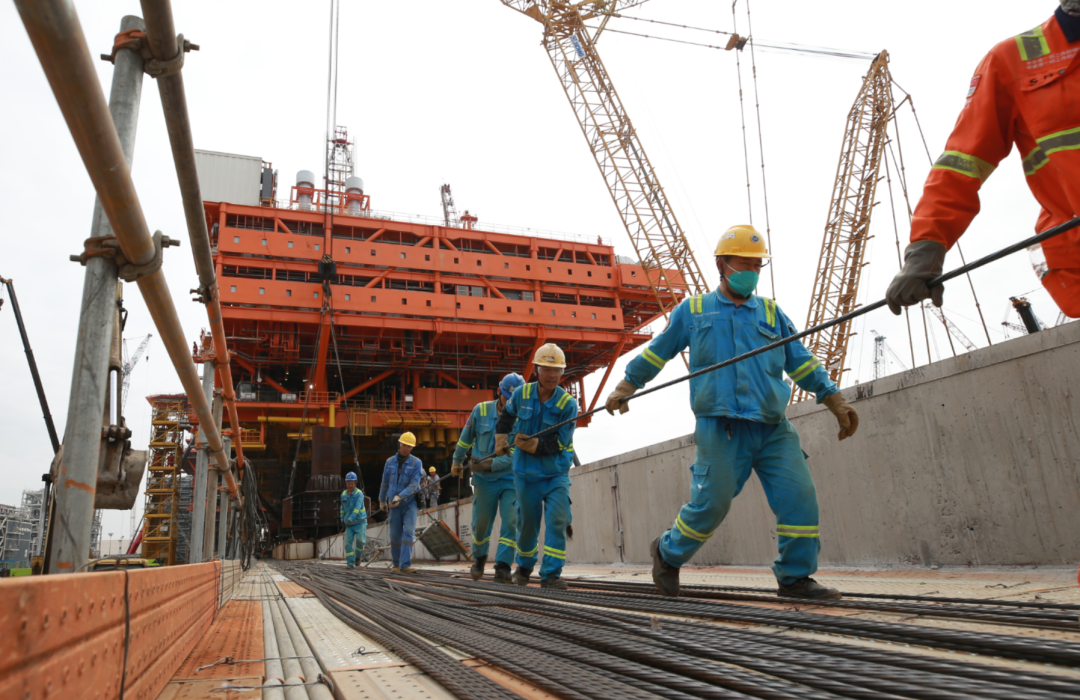 工人正在合作拖拉装船用钢丝绳，上百根钢丝绳将拖拽着一万五千余吨的组块滑移上船