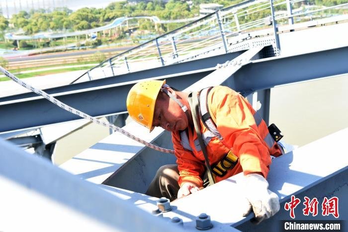 5月1日，九江桥工段桥隧工爬上京九铁路九江长江大桥三大拱检查钢梁螺栓，防止螺栓松动掉落到公路面。　王浩 摄