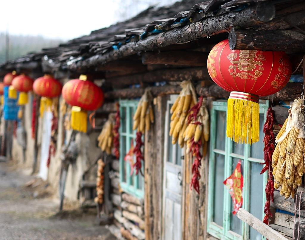 木屋外悬挂着灯笼和玉米、辣椒（2023年4月6日摄）。新华社记者许畅 摄