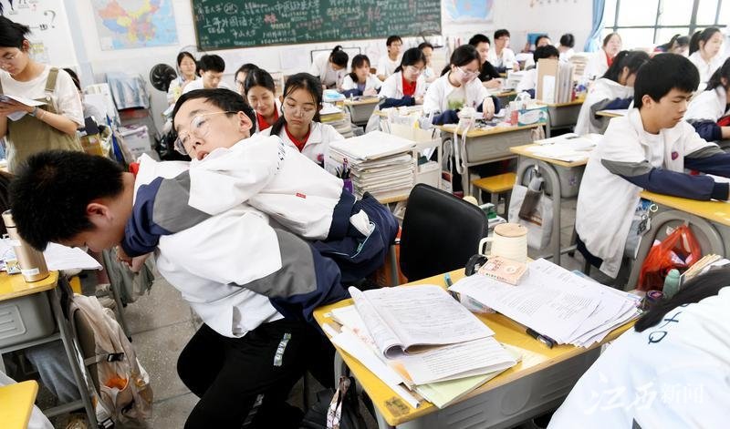 朱金祥（左）把钟华强放到课堂座位上后，都要把他摆正好，确认安全后才回到自己的座位上。