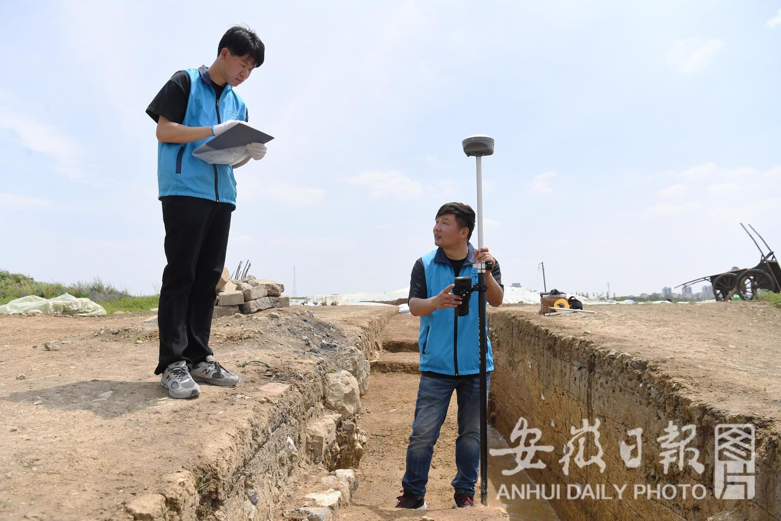 4月27日，在凤阳县的明中都遗址，年轻的考古队员陈怀南（左）与王瑞测量探沟的高程数据。