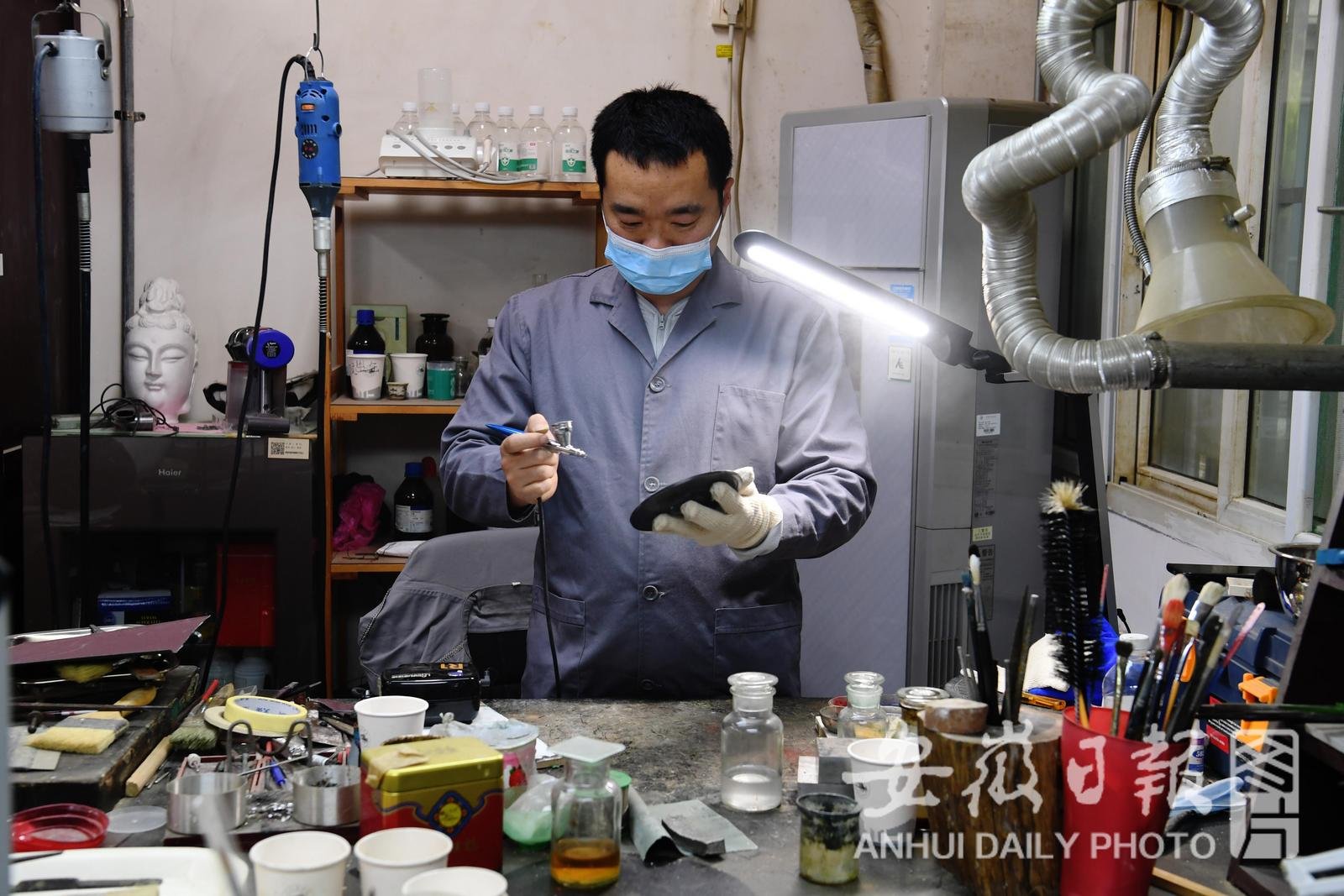 4月26日，在省博物院文物科技保护中心青铜修复室，39岁的李立新修复唐代花卉纹铜镜。