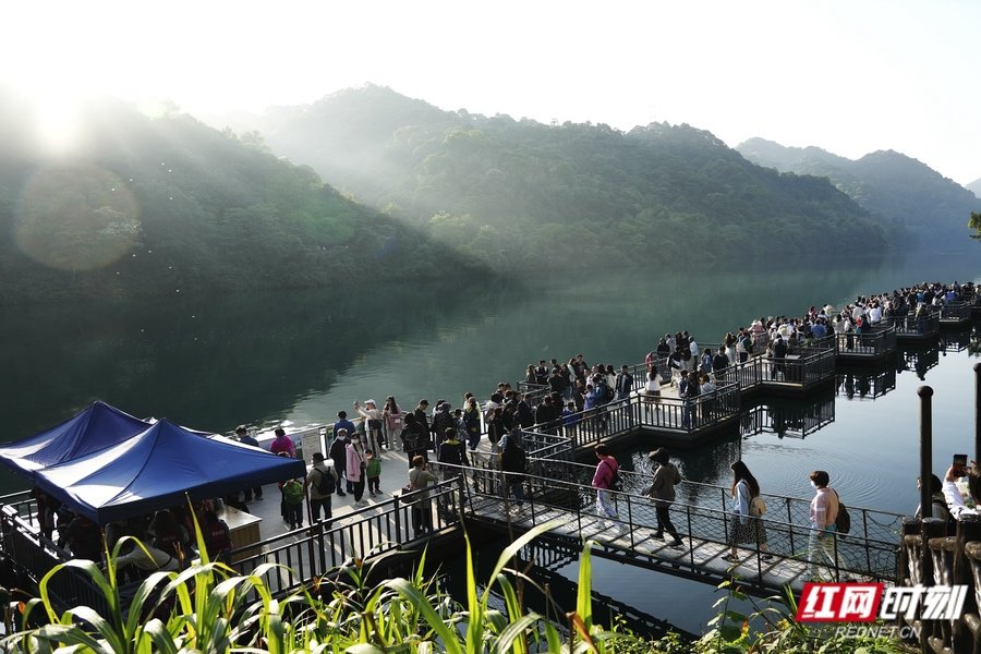 郴州东江湖景区，游客行走在浮桥上欣赏小东江的美景。
