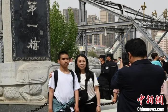 图为游客在中山桥旁的“黄河第一桥”纪念碑前拍照留念 戴文昌 摄