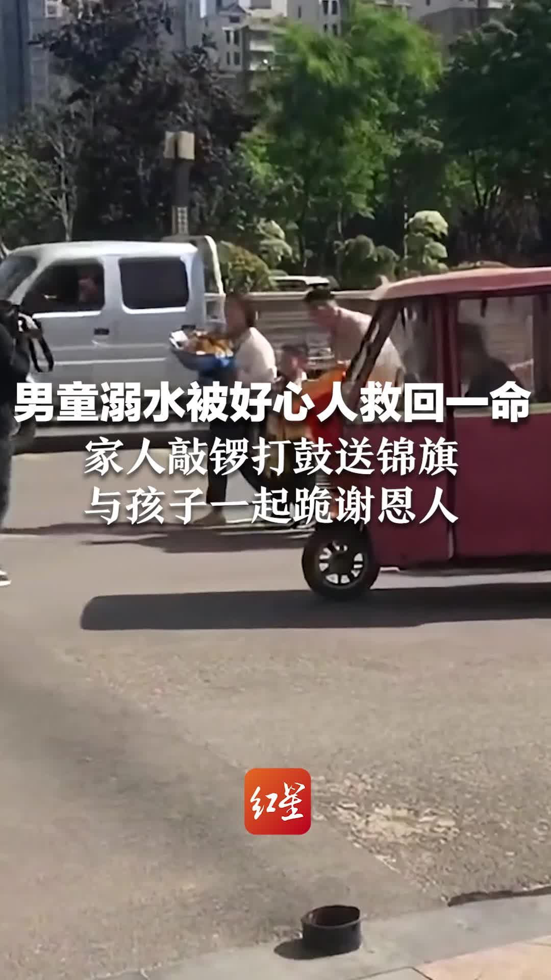 男童溺水被好心人救回一命，家人敲锣打鼓送锦旗，与孩子一起跪谢恩人