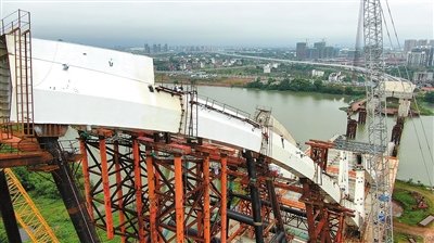 工人在吊装焊接创业大桥的桥梁钢结构拱肋。