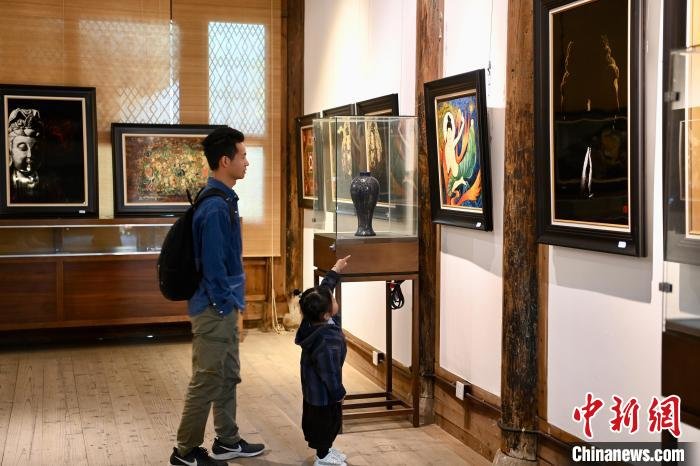 大人带小朋友参观展览。　王东明 摄
