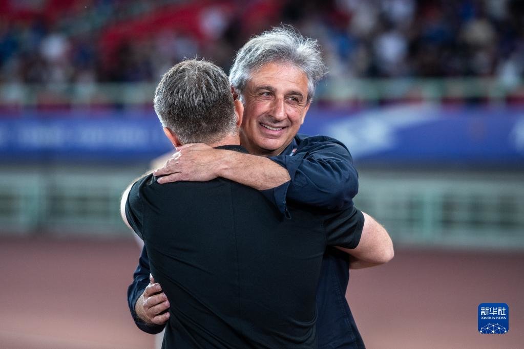 5月5日,浙江队主教练乔迪(右)和武汉三镇队主教练佩德罗在比赛前拥抱。新华社记者 伍志尊 摄