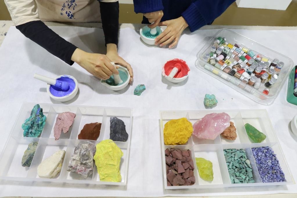 5月11日,学员在位于敦煌市的莫高里工匠村用天然矿石制作颜料.