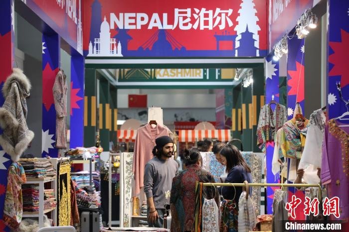 图为海外客商向顾客介绍商品。　阚力 摄