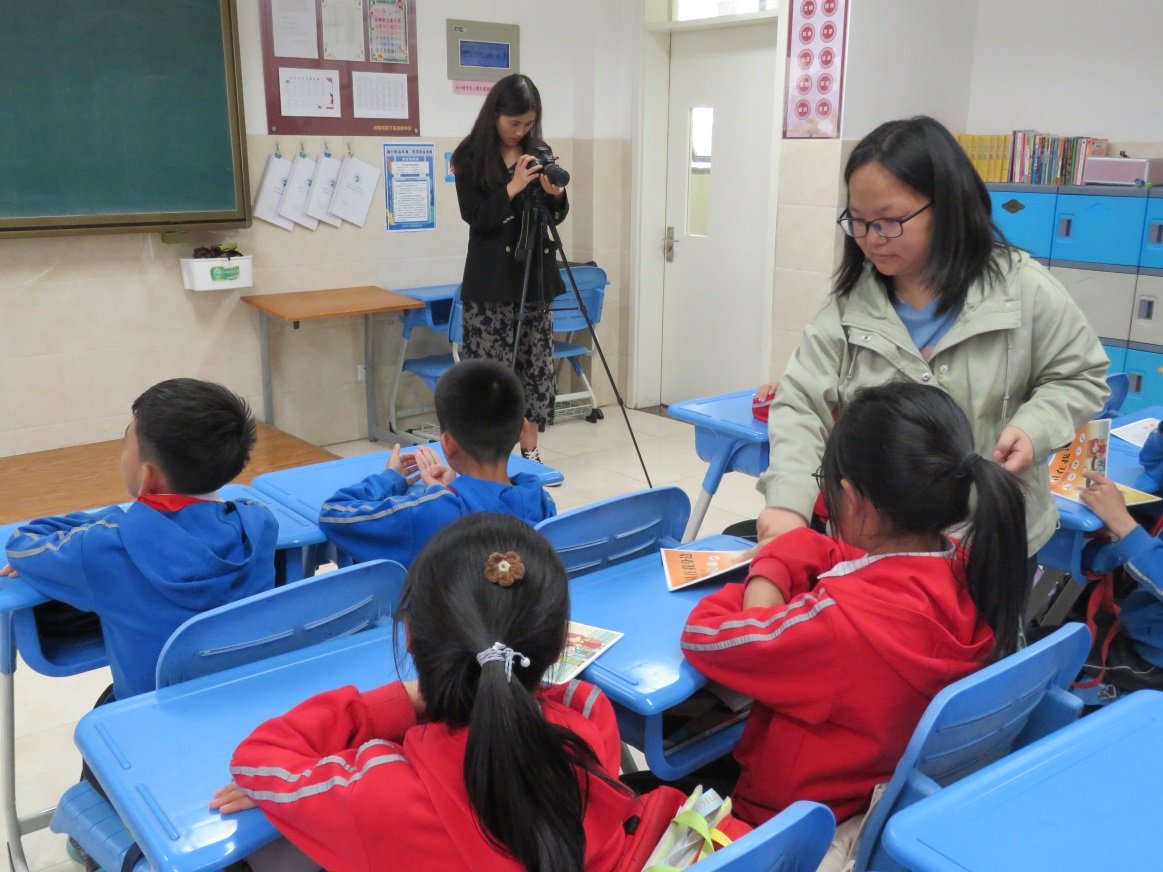 科普志愿者为学生们发放《计量在我身边》计量科普图书