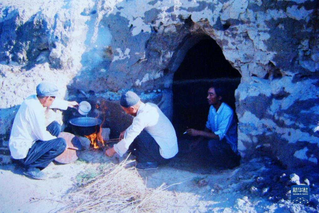 1983年，“六老汉”一代治沙人在“地窝子”生火做饭。新华社发（八步沙林场供图）