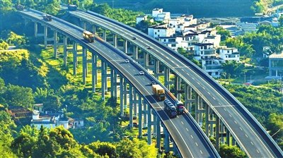 在赣州市绕城高速公路杨仙岭隧道引桥上，车辆往来驰骋，沿途乡村美景怡人，宛如画卷。