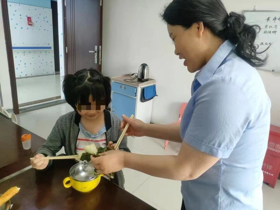 工作人员在照顾萱萱。