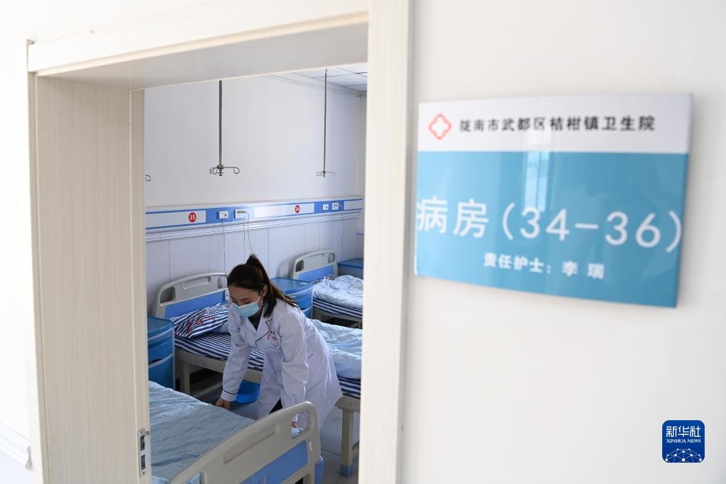 在武都区桔柑镇卫生院住院部病房，李瑞在整理患者床铺（5月11日摄）。新华社记者 范培珅 摄