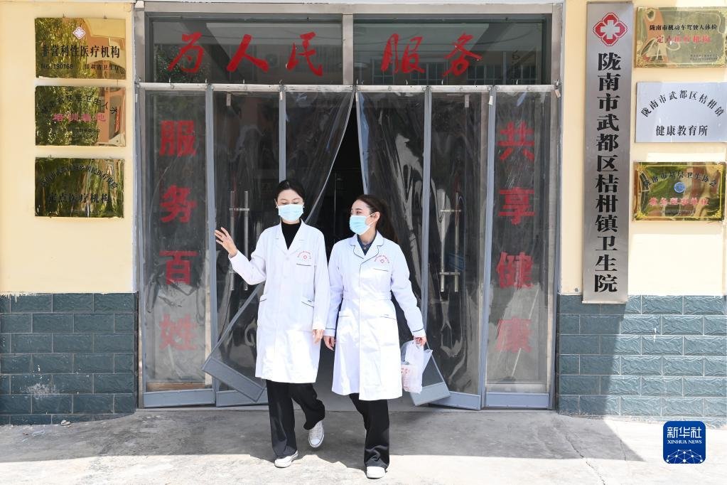 在武都区桔柑镇卫生院，李瑞（右）外出前往出院患者家中回访（5月11日摄）。新华社记者 范培珅 摄
