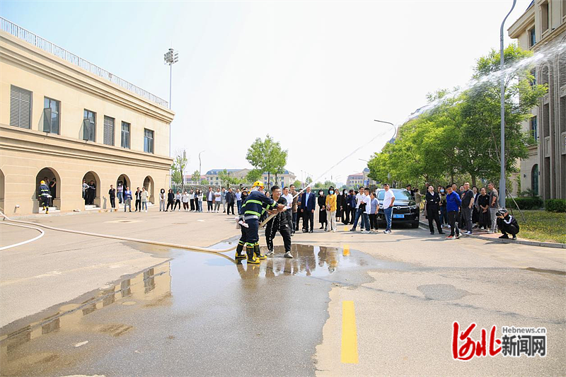 图为唐山海运职业学院教职工正在练习使用消防高压水枪。