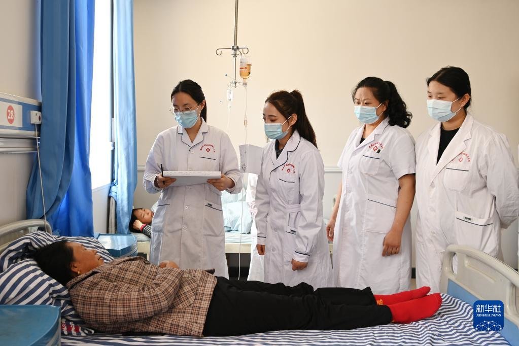 在武都区桔柑镇卫生院，李瑞（左二）和同事们一起例行查房（5月11日摄）。新华社记者 范培珅 摄