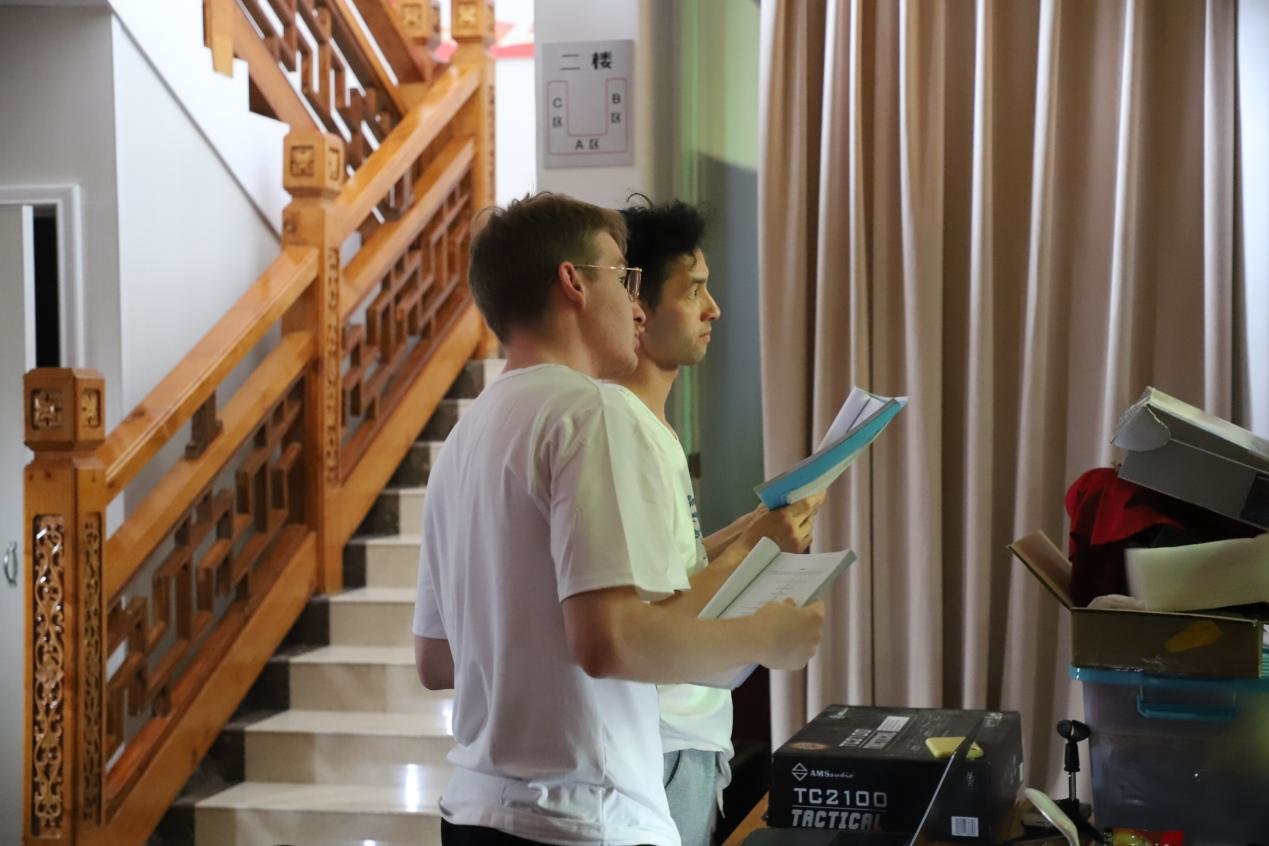 柯文杰和乔屿修拿着台本观看学生表演情况