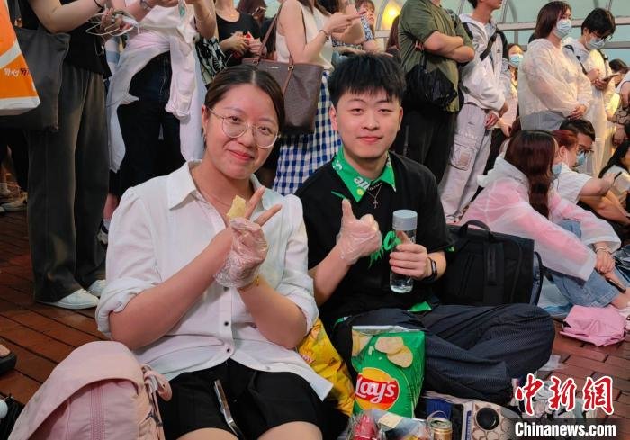 5月13日，周杰伦“嘉年华世界巡回演唱会2023香港站”在中环举行，吸引各地歌迷来港，内地歌迷周先生(右)与朋友接受中新社记者采访。中新社记者 刘大炜 摄