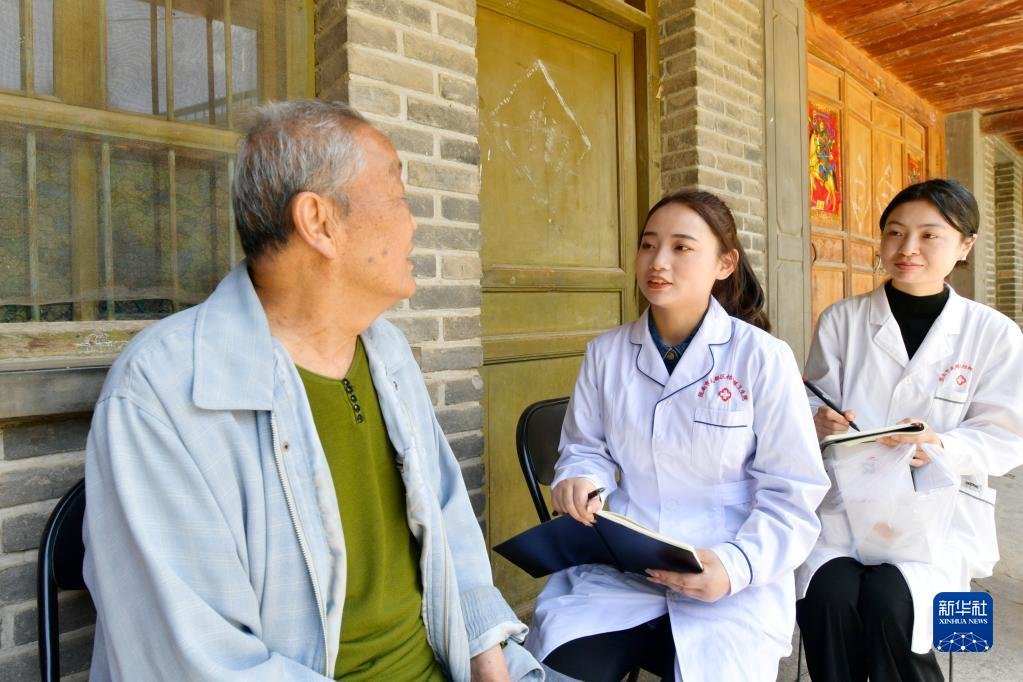 在武都区桔柑镇大岸庙村，李瑞（左二）和同事回访患者出院后身体情况（5月11日摄）。新华社记者 范培珅 摄