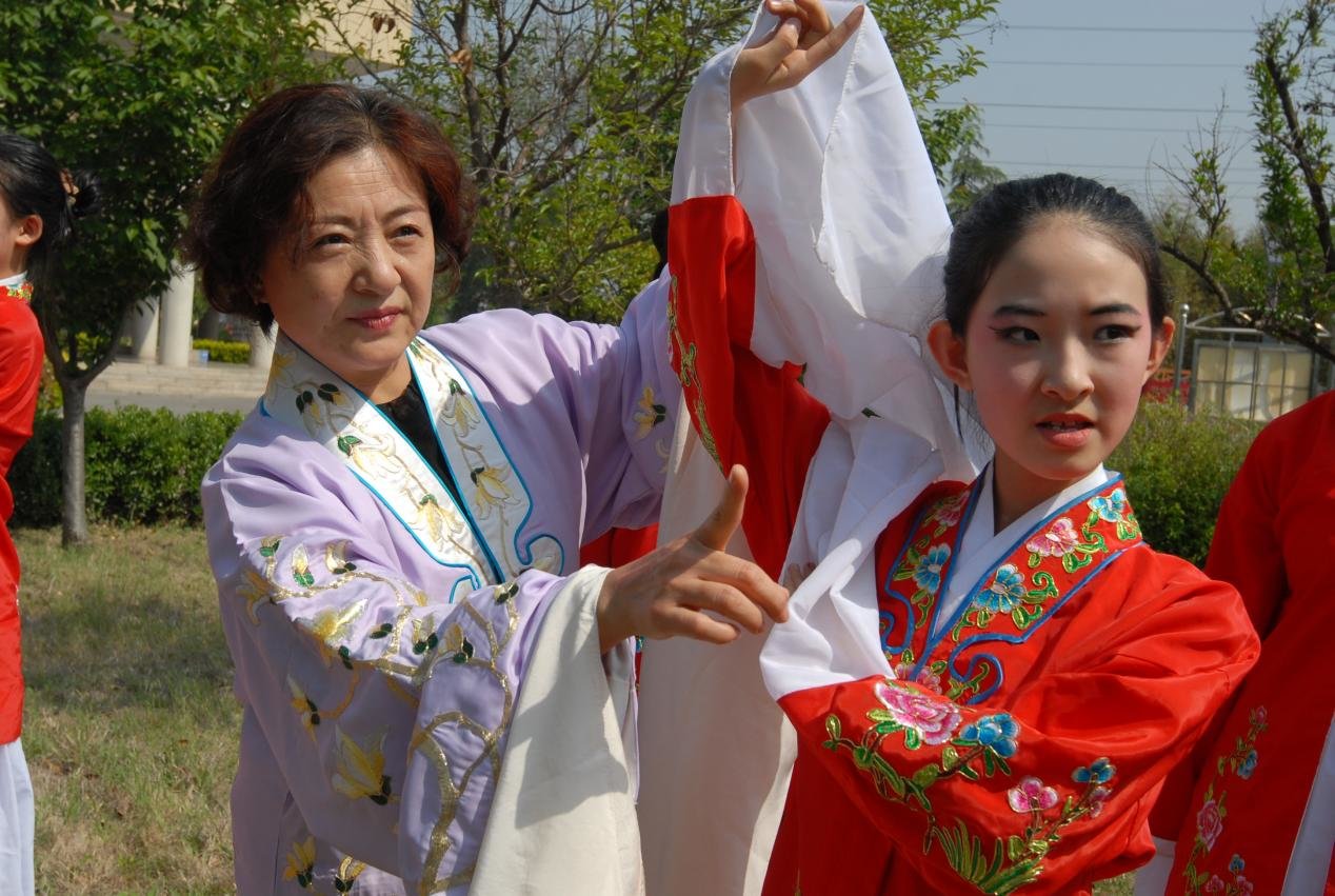 5月15日，在青岛市即墨区第四实验小学，国家级非遗项目柳腔传承人袁玲（左一）在教唱当地地方戏柳强选段。
