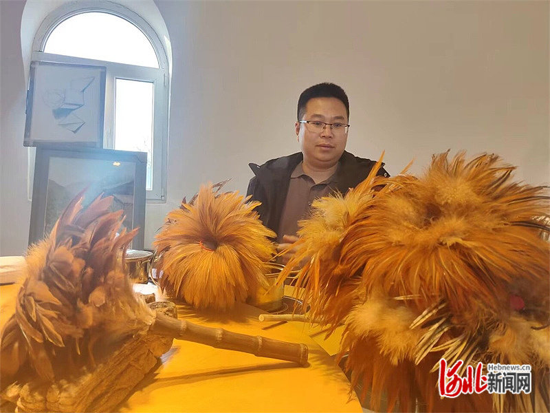 图为刘文豪检查鸡毛掸子产品质量。